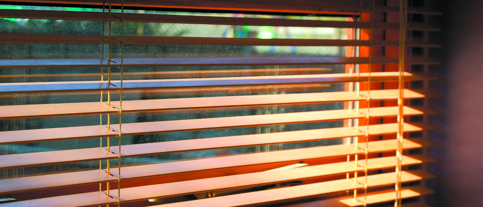 open wooden blinds with sun shining through